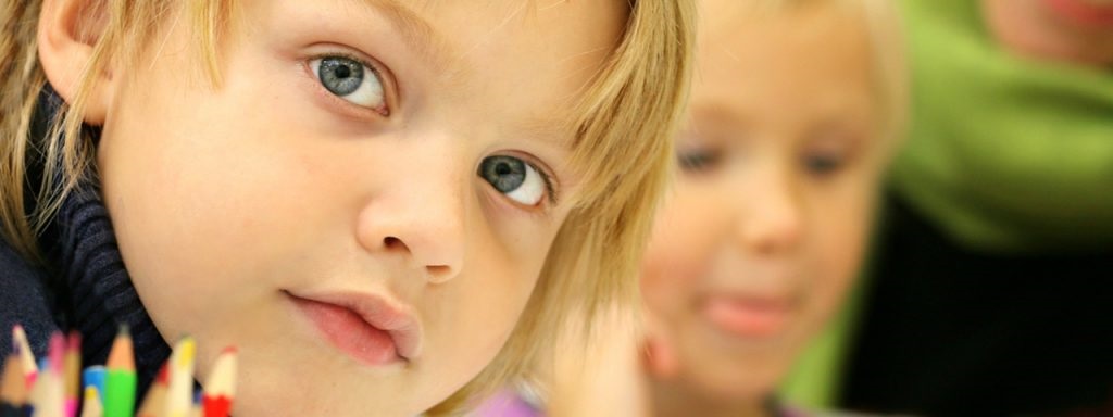 young boy smile sitting next to girl